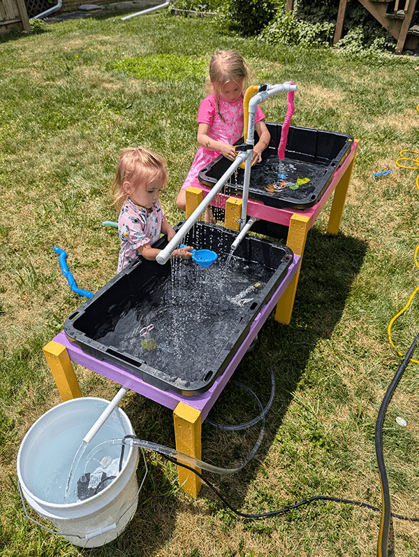 Children playing at a DIY water table outdoors